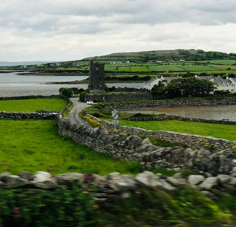 Stone tower in a green rural landscape.