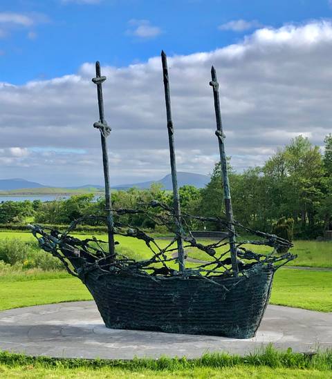       Sculpture with mountainous landscape in background.
  
