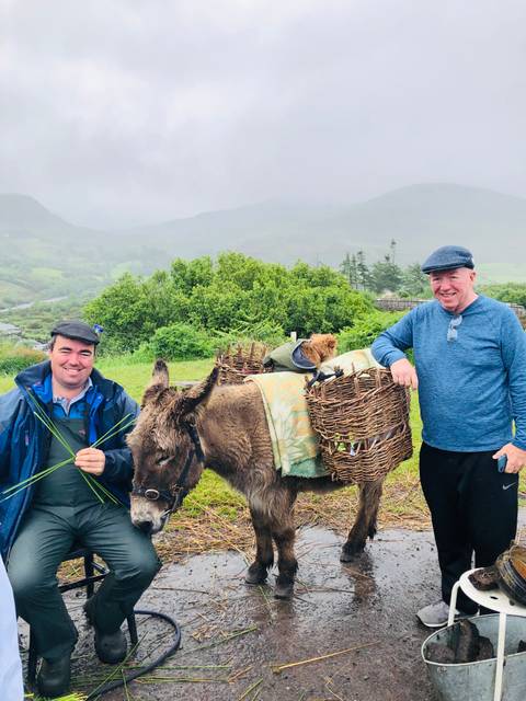 Men posing with a donkey.