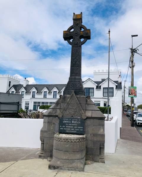 Stone monument with building behind.