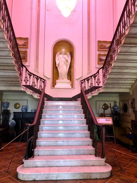       Interior with staircase and statue.
  