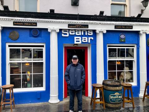       Man standing outside Sean's Bar.
  