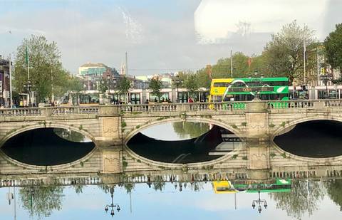       Bridge over river with bus reflection.
  