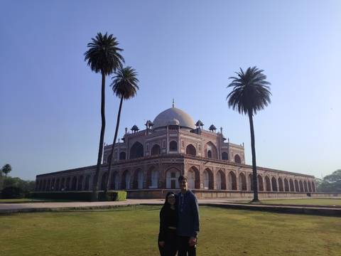 Couple posing in front of a historic mausoleum.