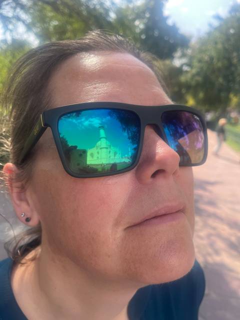 Close-up of sunglasses reflecting a monument.