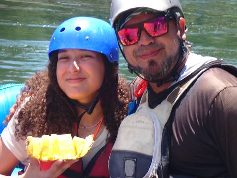 Two people smiling with life jackets on a boat.