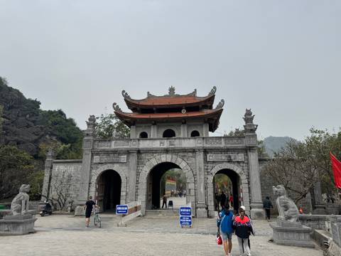       Entrance of an ancient temple with visitors and intricate details.
  