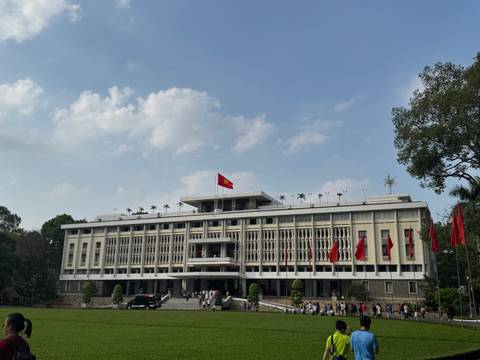       A grand building with a Vietnamese flag.
  