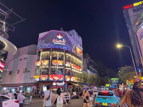 Vibrant nightlife scene with a colorful building facade.