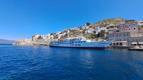 A cruise ship docked at a picturesque coastal town.