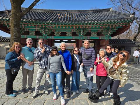 Group of tourists in front of a traditional Korean gate.