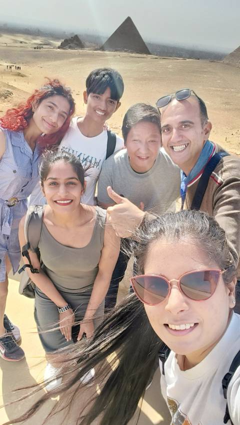       Group selfie with people smiling at the camera.
  