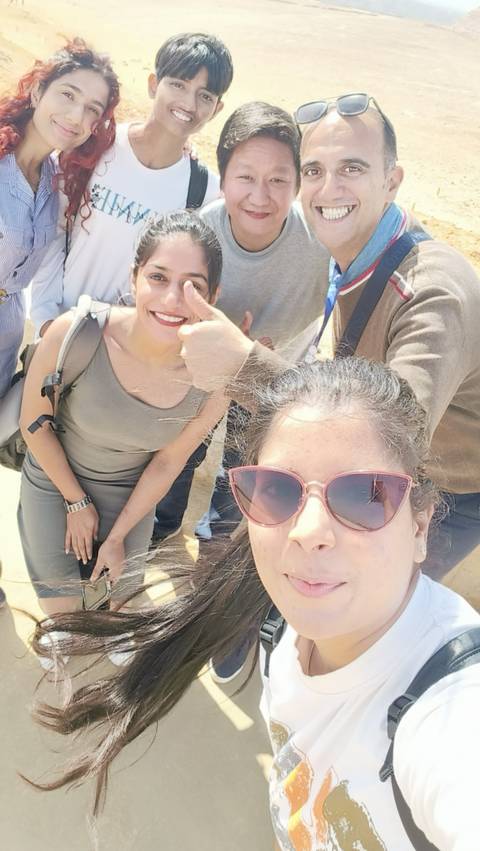       Group selfie with people smiling at the camera.
  