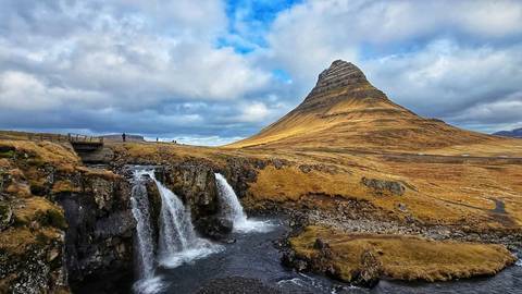 Iconic view of Kirkjufell mountain with a cascading waterfall.
