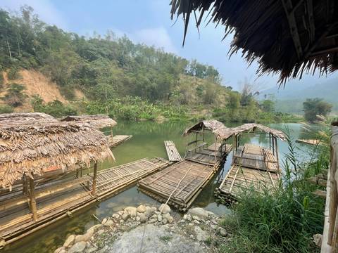       Bamboo rafts on a serene river bank.
  