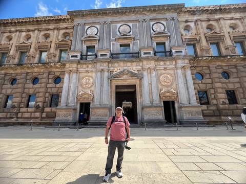       Person posing in front of a historic building with ornate details.
  