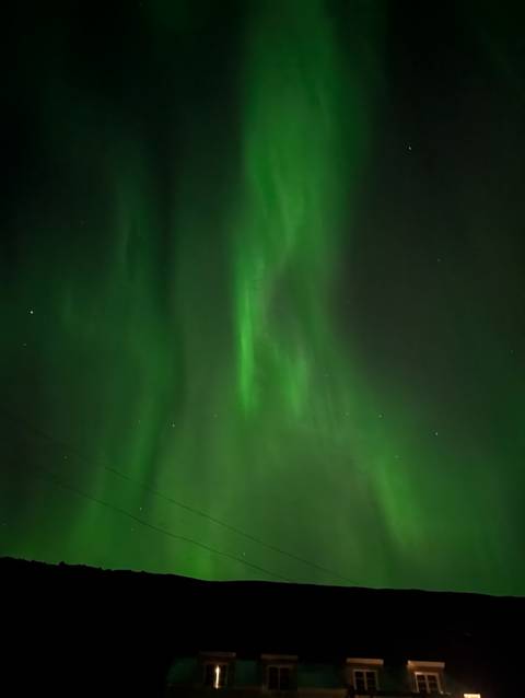       Green hues of the northern lights in a clear night sky.
  