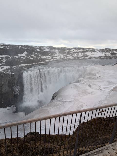       Powerful waterfall surrounded by snowy rocks.
  
