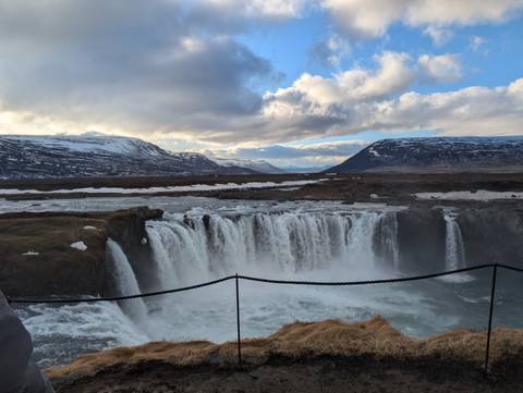       Waterfall cascading over rocks into a scenic valley.
  