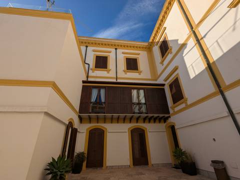 Classic building facade with wooden balconies and shutters.