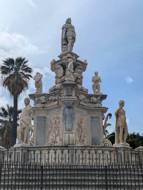       A baroque fountain with sculptures and intricate relief on display.
  