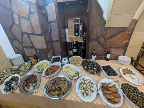       Buffet spread with a variety of meat, vegetables, and wines.
  