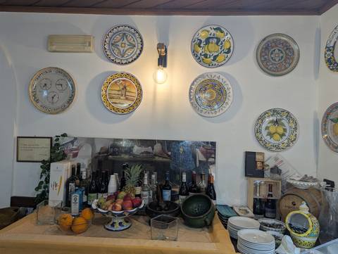       Wall adorned with decorative plates and a variety of wines.
  
