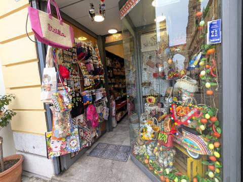       Storefront filled with colorful souvenirs and gifts.
  