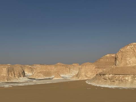       Desert landscape with unique rock formations under a clear blue sky.
  