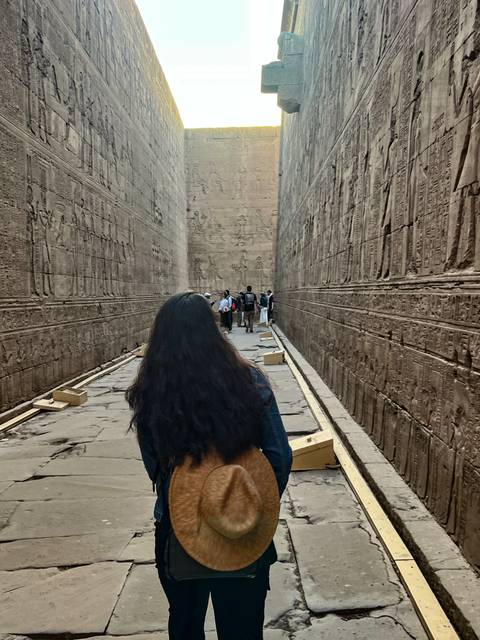 Interior of an ancient Egyptian temple with tourists.