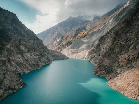 Aerial view of a turquoise lake surrounded by mountains.
