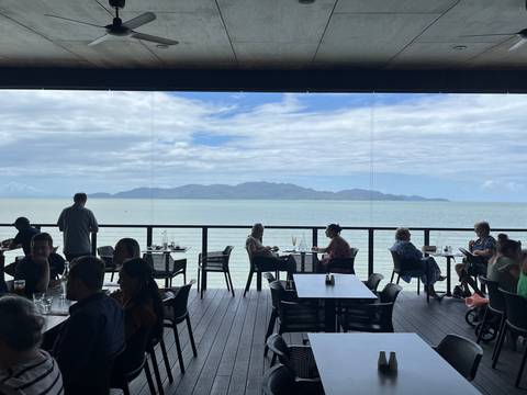       Dining area overlooking the ocean with people seated.
  