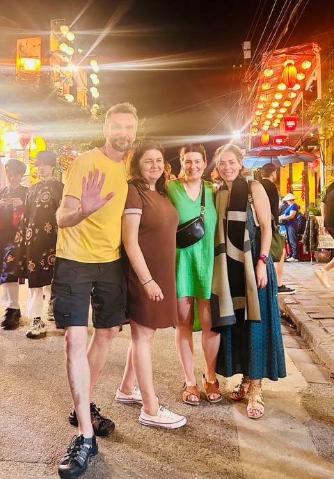 Group of people posing on a bustling street at night.