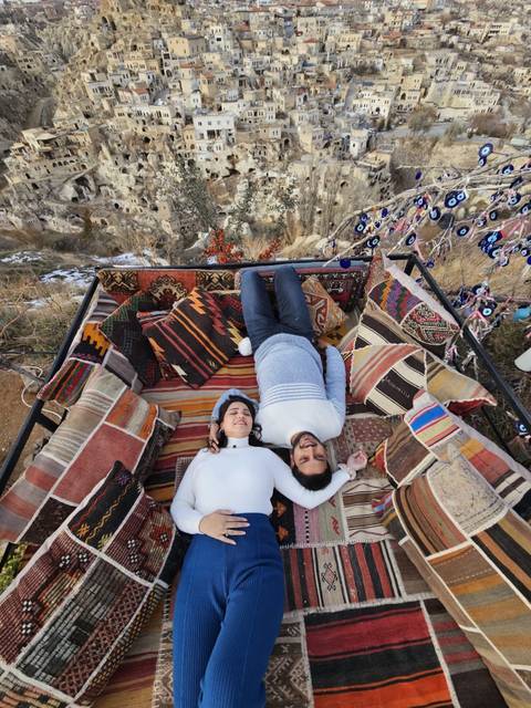 Two people lying on cushions with colorful patterns.