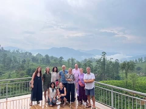 Group of people posing with a view of greenery.