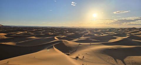 Sun setting over a vast desert landscape.