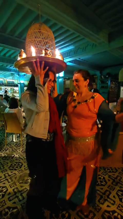 People dancing indoors with warm lighting.