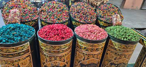 Barrels of vibrant dried flowers in a marketplace.