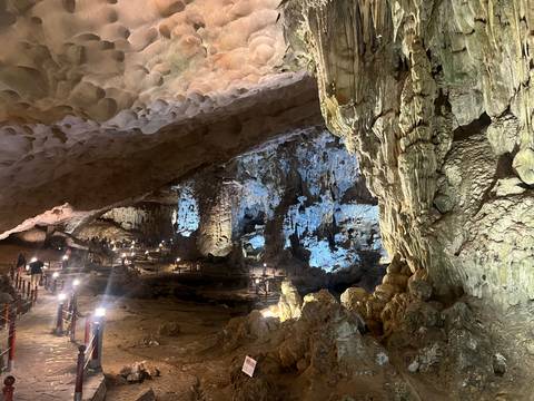 Interior of a large cave with illuminated rock formations.