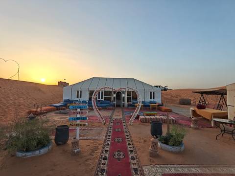 A luxury desert camp with ornate decoration at sunset.