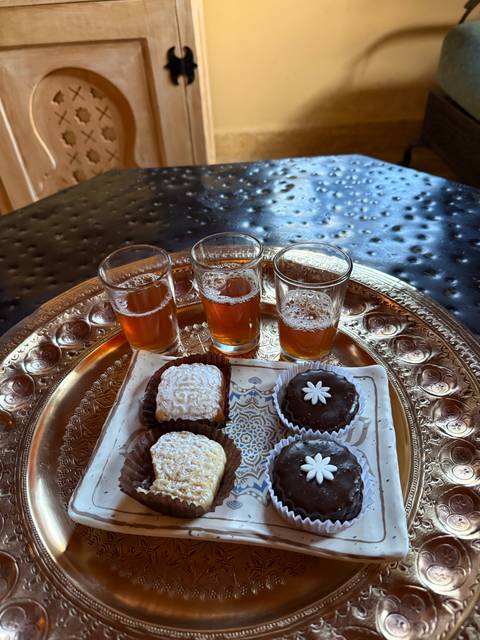 Traditional Moroccan tea and assorted sweets on a decorative tray.