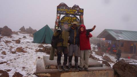 Group of hikers posing at a mountain peak in Kilimanjaro National Park.
