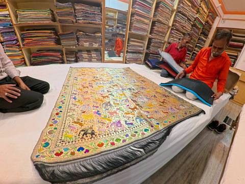 Artisan showcasing traditional embroidered cloth.