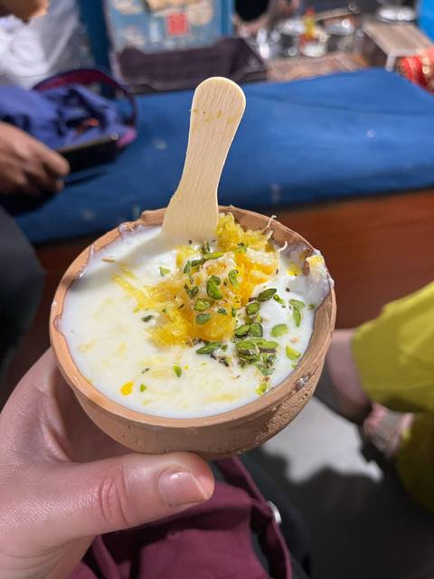 Traditional Indian dessert garnished with nuts served in a clay cup.