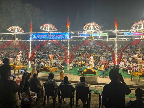 Evening ritual performance on a stage before a large crowd.