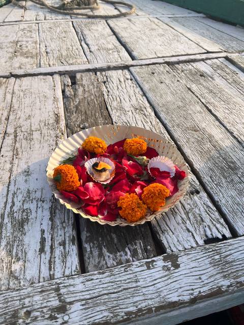 Plate with vibrant flower petals offering.