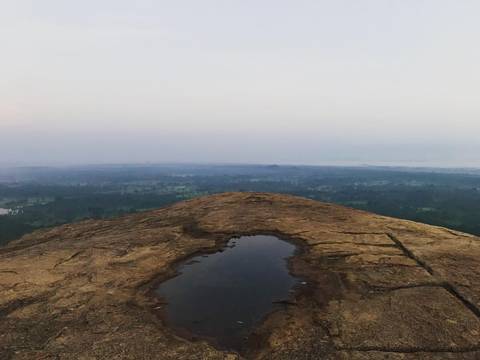Barren hilltop with a small pond.