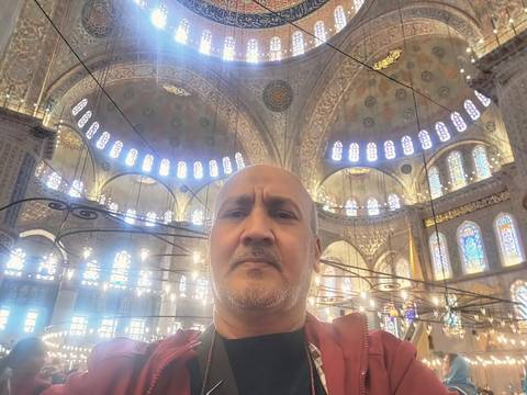 Person inside a grand historical structure with ornamental ceilings.