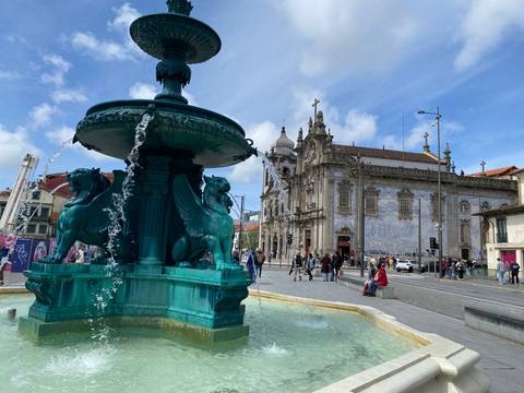 Fountain in a city square with architectural buildings surrounding it.