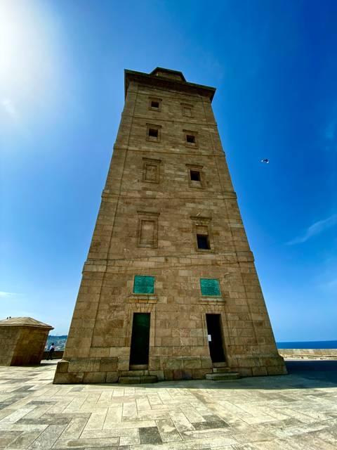       Tall stone tower under a clear blue sky.
  